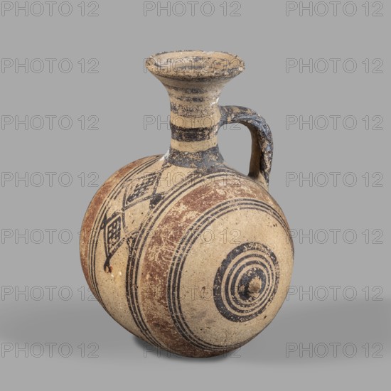 Barrel-shaped jug, unknown Cypriot workshop, ca. 850–600 BC, Cyprus Arsinoe. vessel. A vessel with a barrel-shaped body terminated on both sides by small protrusions. The cylindrical neck terminates in a cup-shaped spout. A band-shaped vise connects the body to the neck midway up. The decoration, finished with brown paint, consists of concentric bands encircling the barrel. Two wide light-brown bands on either side of the vise are framed on either side by narrow dark-brown bands. At the protrusions, the bands group into a set of concentric circles. Transverse bands between two vertical bands decorate the vise. A series of concentric belts on the neck. Height 12 cm; width 10 cm., A rounded ceramic vessel with a narrow neck and a flared rim sits against a plain background; the surface shows a weathered beige base with decorative bands and geometric patterns in dark gray and reddish-brown, and a single curved handle connecting the neck to the shoulder, with worn and chipped areas revealin...