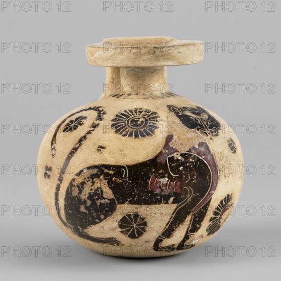 Aryballos with a depiction of a panther, Seated Panther Painter c. 620–590 BC. Spherical aryballos with a low cylindrical neck and squat belly. Image of a seated panther facing right with a long curled tail. Visible red retouching; details highlighted with engraved lines. One rosette of the filling ornament is unfinished. Small amount of filling ornaments rosettes. Small rays visible near the neck. Four lines on the vise. Remnants of a ray ornament at the bottom. Technology: Smooth surface, good-quality glossy varnish. Notes: Reconstructed rim. Visible chips, cracks, and impurities. Clay color: 2.5 YR 8/3 pale yellow. Black color: 5 YR 2.5/1 black. Red color: 7.5 R 4/2 weak red. Attributed origin: Corinth. Type: aryballos vessel. Date: 620–590 BC. Height 6.9 cm; width 6.6 cm; weight 0.066 kg; rim diameter 3.7 cm., A rounded ceramic vessel with a short neck and a flaring flat rim, predominantly beige with areas of darker wear, decorated with painted motifs in black and dark reddish-brow...