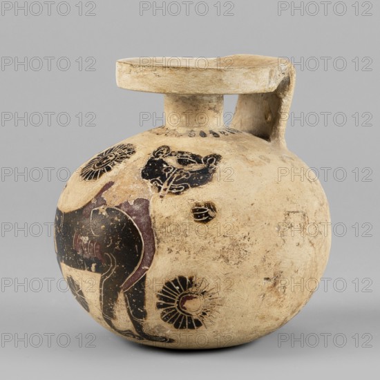 Aryballos with a depiction of a panther, Seated Panther Painter c. 620–590 BC. Spherical aryballos with a low cylindrical neck and squat belly. Image of a seated panther facing right with a long curled tail; details highlighted with engraved lines and visible red retouching. One of the rosettes of the filling ornament is unfinished. Small amount of filling ornaments rosettes; small rays visible near the neck. Four lines on the base/foot. Remnants of a ray ornament visible at the bottom. Technology: Smooth surface, good-quality glossy varnish. Notes: Reconstructed rim. Visible chips, cracks, and impurities. Clay color: 2.5 YR 8/3 pale yellow. Black: 5 YR 2.5/1. Red: 7.5 R 4/2 weak red. Provenance/Origin: Corinth. Type: aryballos vessel. Date: 620–590 BC. Dimensions: height 6.9 cm; width 6.6 cm; weight 0.066 kg; rim diameter 3.7 cm., A rounded ceramic vessel with a short neck and a flat round rim and handle, shown against a gray background, in beige and tan tones with areas of darker wea...