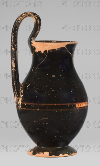 Olpe type of jug for liquids with inscription, unknown Attic workshop; Crito ca. 550–500 BC inscription/artist. Black-finished olpe with a clay-coloured cartouche at the point of maximum diameter bearing Crito's signature KRITONE POIESEN Kriton made it. Medium-sized olpe, rim edge slightly turned outwards; low neck gently transitioning into a concave, spherical belly clearly distinguishable from a low conical foot with a recess; bottom slightly convex. Profiled handle shaped with clearly distinguishable edges. On the inner side of the rim two clay nodules one reconstructed are visible, located 4.5 cm apart on the side of the handle. Greek ceramics; pottery marks; Greek inscriptions. 550–500 BC. Origin: Attica, Athens. Olpe vessel. Height 26 cm; width 13.5 cm; depth 15.5 cm; weight 0.58 kg., A single tall ceramic jug with a curved handle attached near the rim and upper body stands against a plain light gray background; the jug has a glossy black surface with areas of exposed terracotta ...