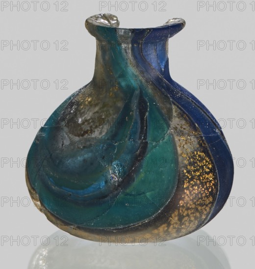 Unguentarium with carnation with a gold ribbon; with a bulging belly. 1st half of the 1st century BC. Type: Isings form 7. Mosaic glass small bottle with a cylindrical neck; sagging. Height: 2.9 cm; Body diameter: 2.6 cm; Weight: 0.008 kg. Unknown workshop; possibly Egyptian workshop, and unknown Italian workshop ., A small rounded glass vessel with a flared neck and a wavy, ribbed surface, showing swirling bands of deep blue, teal, green, and dark turquoise glass, with areas of cloudy translucent gray and patches of golden speckling on one side; the glass surface shows irregularities, seams, and small chips, and the object casts a faint reflection on a neutral light-gray background.