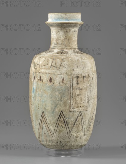 Flask with an egg-shaped belly and a slightly rounded bottom. The flask's arms are sloping and short, merging into a cylindrical neck ending in a profiled rim. The front part is painted. A hieroglyphic inscription runs through the center. Clay vessel, painted Egyptian pottery, Late Period, 664–332 BC. Height 14.3 cm; diameter 6.5 cm belly. Maker, findspot Goluchów Greater Poland Voivodeship., A tall, narrow ceramic vessel with a flared rim and long neck sits against a solid gray background; the vessel's surface is weathered and predominantly off-white or beige with areas of pale blue and muted green patina, and shows hand-drawn linear decorations in dark brown or black including angular zigzag patterns near the base and small teardrop shapes below the shoulder, plus faint circular and star-like motifs around the neck and a rectangular panel sketched on one side; the rim has a band of light blue, and the piece rests on a clear circular stand.