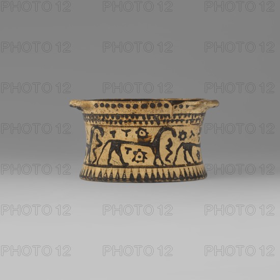 Orientalising pyxis with an animal frieze in the Silhouette style, Images of animals; Middle Corinthian period, cats. Thin-walled pyxis with a straight rim, slightly concave body walls, and a flat bottom. Small vices mounted horizontally just near the edge of the rim. The main decorative band, bounded at the top and bottom by a thin line of varnish, depicts figures of animals executed using the silhouette technique. Between the silhouettes there are simplified filling ornaments. Clay color: 5 Y 8/2 pale yellow Varnish color: 5 Y 2.5/1 black Dating: 590–570 BC Middle Corinthian period. Place of origin: Corinth. Object type: pyxis vessel. Dimensions: height 5.3 cm, width 10.2 cm, depth 8.5 cm, weight 0.102 kg., A shallow, cylindrical ceramic vessel sits centered against a gray background, showing a beige base color with black painted decoration; the body flares slightly at the rim which has a couple of small protruding tabs, and the rim edge and interior top band are marked by rows of bl...