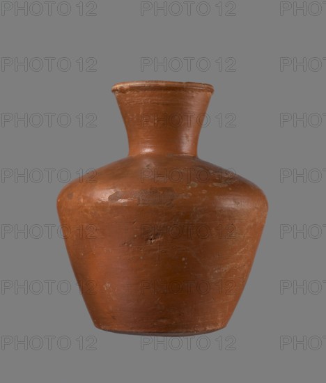 Jug, ceramics, Egyptian pottery, vessel, clay. Medium-sized jug with a biconical body, widest at about half its height. Wide shoulders, not very sloping. Wide, almost cylindrical neck widening towards the spout; neck height about one-third of the vessel. Profiled, irregular spout, slightly raised and extended on one side, forming a small spout. Spout almost triangular in cross-section, with an approximately millimeter-sized cylindrical bulge at the center of the outer profile. Bottom almost flat, very slightly rounded. Made of Nile clay NB1 Vienna System. Neck was formed separately and connected to the shoulders. Outer surface leveled, covered with an engobe, and polished. Inner surface leveled except for the neck, which was also covered with engobe and polished. Color reddish-brown. Well preserved; rim slightly chipped in two places and engobe worn off in places on the outer surface. Analogous to a similar jug from Edfu; dated to the 6th Dynasty. Comparable typology: Reisner, Mycerinu...