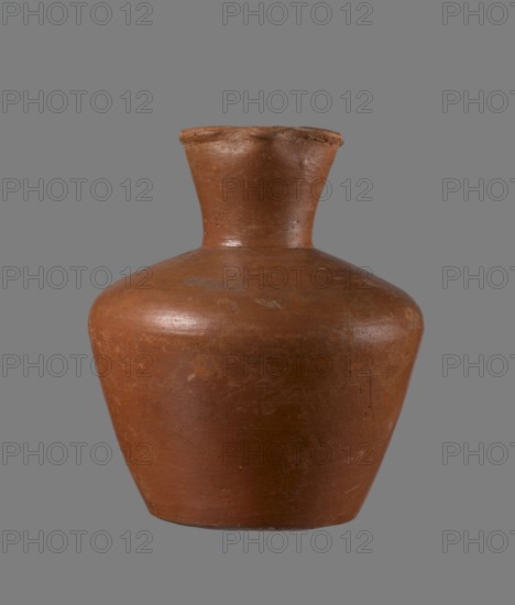 Jug, ceramics, Egyptian pottery, clay vessel. Medium-sized jug with a biconical body, widest at about half its height; wide shoulders, not very sloping. Wide, almost cylindrical neck widening toward the spout, the neck about one-third of the vessel's height. Profiled, irregular spout, slightly raised and extended on one side forming a small spout; spout almost triangular in cross-section with an approximately millimeter-sized cylindrical bulge on the outer profile. Bottom almost flat, very slightly rounded. Made of Nile clay NB1? per Vienna System. Neck likely made separately and joined to the shoulders. Outer surface leveled, covered with engobe and polished; inner surface leveled except for the neck, which was also engobed and polished. Reddish-brown color. Quite well preserved; rim slightly chipped in two places and engobe worn off in places on the outer surface. Dated to the 6th Dynasty; Old Kingdom, from Edfu. Dimensions of a comparable example: height 20.5 cm; rim diameter 8.5 cm...