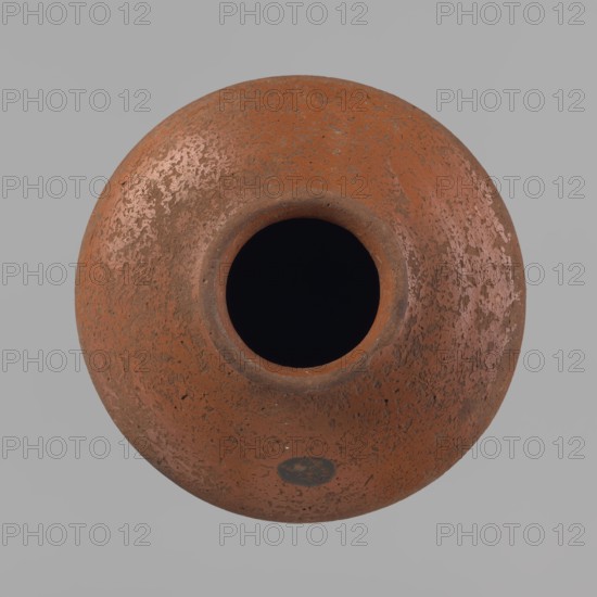 Vessel, Egyptian pottery clay vessel, c. 2686–c. 2181 BC Old Kingdom; from Edfu; vessel, height 11 cm, rim diameter 6.3 cm, body diameter 14.7 cm, bottom diameter 10 cm., A round, top-down view of a textured clay pot with a central dark opening, showing a rough surface in shades of terracotta, reddish-brown, and patches of lighter pinkish and pale brown tones against a neutral gray background.