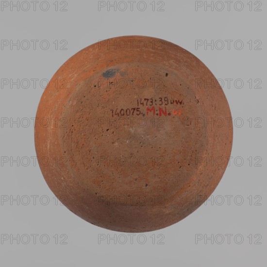 Vessel, Egyptian pottery, ceramic clay vessel, c. 2686–c. 2181 BC Old Kingdom, from Edfu; height 11 cm, diameter 6.3 cm rim, diameter 14.7 cm body, diameter 10 cm bottom., A round, bowl-shaped object viewed from above against a light gray background, the object showing a rough, pitted surface texture and an overall reddish-brown color with darker brown and small black speckles, a few small patches of lighter tan and faint gray discoloration, and a small area of darker, almost black smudging near the rim; there is also a small area of brighter red-orange visible on the surface.
