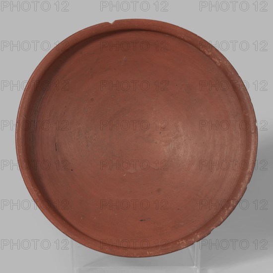 Medum-type bowl, Medum-type bowl of clay with hemispherical body narrowing just below the rim to form a carination, rounded bottom, and straight slightly widening spout whose diameter is slightly larger than the shoulders. Surface even, covered with a red engobe and polished; vessel color red. Fairly well preserved with minor losses on the rim. c. 2494–c. 2181 BC; Old Kingdom, 5th–6th Dynasty, Edfu; vessel. Height 7 cm, spout diameter 26.4 cm, weight 0.90 kg., A round shallow dish with a raised rim, shown from above, in a reddish-brown earthenware color with areas of darker and lighter reddish-brown and a few small dark specks and scuffs; the background is a flat light gray and the dish sits on a translucent support that is faintly visible at the bottom.