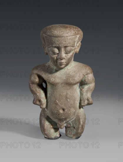 Figurine/amulet of a Ptah-dwarf Pataikos, naked dwarf man with a large head and wide forehead, short arms with clenched fists pressed to the hips, and short legs broken off at the knees; careful modelling. Late Period, Egypt, 7th–4th century BC. Materials: not specified. Dimensions: height 6.5 cm, width 3.7 cm, depth 2.6 cm., A small weathered statuette of a standing human figure with a rounded flat-topped head, closed eyes, and a neutral mouth, shown from the front; the figure has short arms bent at the elbows with hands resting near the hips, a rounded torso with a faint belly button, and short thick legs with visible toes, all rendered in a rough textured surface. The object displays a mottled color palette of brown and green with patches of lighter and darker tones, and the background transitions from dark gray at the top to a lighter gray near the bottom.
