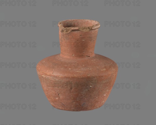 Jug, A small handleless jug with a biconical body, widest at about half its height. Broad, rather flat shoulders; a wide, almost cylindrical neck that widens slightly toward a profiled, irregular spout which slopes down on one side and extends to form a small pouring lip. Spout cross-section triangular with an approx. 1 mm central indentation on the outer profile. Neck was shaped separately and attached to the shoulders. Bottom almost flat, very slightly rounded. Made of Nile clay NB1/2, per the Vienna System. Outer surface and inner rim/neck leveled and covered with an engobe and polished/smoothed; remaining inner surface leveled. Red-brown in color. Nearly complete with a small fragment of the rim missing; outer surface slightly worn in places. Old Kingdom, cited as 4th–6th Dynasty c. 2686–c. 2181 BC. From Edfu. Vessel; height 11.4 cm; rim diameter 5.5 cm; shoulder diameter 10.8 cm; bottom diameter 7.1 cm. References: G. Brunton; T. Rzeuska., A single worn clay vessel with a rounded ...