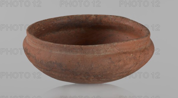 Medum-type bowl, Medum-type bowl, Bowl with a hemispherical shape. The walls bend gently around about 2/3 of the height of the vessel. The rim is straight, perpendicular to the shoulders, slightly irregular. Rounded bottom. The surface of the vessel is even. Vessel colour - red. Vessel glued together from several fragments. c. 2686 - c. 2181 BC; Old Kingdom, Edfu, vessel, height 5.5 cm, diameter 12.6 cm rim, diameter 13.5 cm shoulders, A low, wide ceramic bowl with a rounded body and a slightly flared rim sits against a light gray background, showing a weathered surface with a few visible cracks and rough patches; the bowl is primarily reddish-brown with areas of darker brown and muted orange, and the interior appears darker than the exterior.