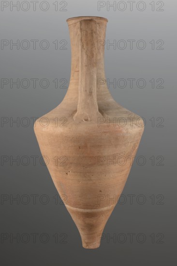 Transport amphora, amphoras, material culture, ancient ceramics, Greek ceramics, transport vessels. The walls of the body separate gently up to 2/3 of the height, then round very much towards a long neck. The edge is separated by a profile; the edge is rounded in the form of a cylinder. Flattened roller handles, attached at the height of the rim, fall vertically towards the narrowing of the body. Fingerprints at the place where the handles are attached on the body. 3rd quarter of the 4th century BC; Mende Greece. Vessel, transport amphora; height 71 cm, dia. 33.5 cm., A single tall clay vessel with a narrow neck and elongated pointed base is shown against a neutral gray background; the surface of the vessel is an earthy light brown with subtle variations of tan and ochre, showing a matte, slightly rough texture with a few small darker specks and faint horizontal striations, and the neck features a raised ridge running from the rim down toward the shoulder.