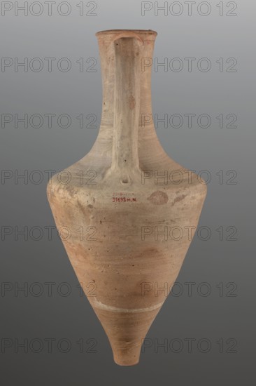 Transport amphora;, 3rd quarter of the 4th century BC; Mende Greece. Vessel transport amphora, height 71 cm, diameter 33.5 cm. Description: The walls of the body separate gently up to 2/3 of the height, then round very much towards a long neck. The rim is defined by a profile and rounded in the form of a cylinder. Flattened roller handles, attached at the height of the rim, fall vertically towards the narrowing of the body. Fingerprints at the places where the handles are attached., ancient Greek ceramics, transport vessel amphora., A tall, narrow-necked ceramic vessel with a pointed base and a single vertical handle running from the rim to the shoulder, showing a surface of light tan and warm beige with areas of pale brown and subtle reddish-brown patches, small darker speckles, and faint streaks of off-white, photographed against a smooth gray background.