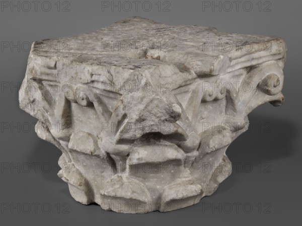 Corinthian capital, Restitution Lubusz Region. Roman architecture; acanthus leaves ornament. Corinthian capital composed of a calathos and thick stems that bifurcate and terminate in volutes supporting the abacus. The crown of leaves, formed by two rows of eight full leaves, occupies half the height of the capital. The leaves are rounded and angled outward. Thick caules with lacings in the form of thick rings grow from the upper row. The volute stems are in the form of flat ribbons. The outer volutes are significantly larger than the inner ones, meeting directly under the projection of the abacus rosette. The abacus is profiled, two-part with extended corners. Two corners, including the volutes, are upholstered. The edges of the leaves are chipped. 4th–5th century late antique period, Roman Empire. Architectural element; architectural detail; element of architectural decoration; capital. Height 24 cm; width 34 cm; depth 33 cm; weight 42.5 kg., A roughly rectangular carved stone fragmen...
