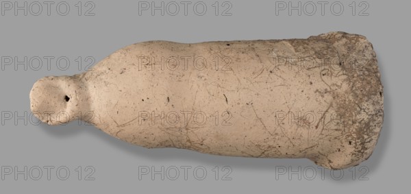 Votive offering in the form of a phallus, votive offering, phalluses, 332–30 BC, Hellenistic period; Etruria, Caere; height 6 cm, width 15 cm, depth 6 cm, length 15.3 cm, weight 0.21 kg., A horizontal, elongated object resembling a worn vessel lies against a plain gray background; the object has a rounded narrow end with a small hollow and a wider, slightly irregular opposite end with a rough, textured rim. The surface is predominantly a light beige or tan color with scattered darker brown and gray speckles, scratch-like markings, and patches of darker brown near the wider end. Shadows beneath the object create a subtle darker gray outline on the background.