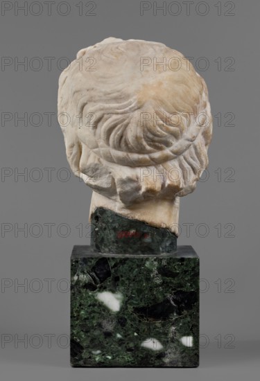 Head of Alexander the Great, unknown Roman workshop. Alexander III the Great King of Macedonia; 356–323 BC. Male portrait, Roman sculpture, Roman copy from a Greek original — head. The head of a young man is clearly turned to the left in a pathetic manner. The head is articulated at the base of the neck. The face is oval, the skeletal structure is not emphasized. The mouth is prominent, with slightly parted lips. The nose is straight, reflected at the tip. The eyes are almond-shaped, deep-set, and the eyebrows are expressive, protruding strongly above the eyeball. The forehead is flat, low, and covered with lush locks of hair. The hairstyle consists of loosely arranged, slightly curled locks. Above the forehead, shifted off-axis to the right, a lock of hair is visible, radiating outwards, slightly raised and clearly different from the other locks. At the back of the head, the hair is arranged in wavy locks, with only the lower part being freely arranged. Dated 140–160 AD previously dat...