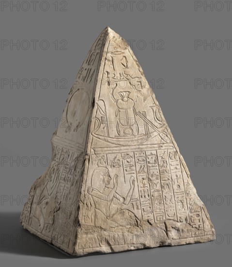 Pyramidion of a deceased named Paser and his father Turobai;, Paser ca. 1295–1186 BC and Turobai ca. 1295–1186 BC. Materials: stone architectural element; sepulchral funerary architecture; Egyptian, New Kingdom, 19th Dynasty reign of Ramesses II. Found at Deir el-Medina House no. 1312. Function: pyramidion. In the lower part Paser or his father Turobai are depicted crouching with both hands raised; surrounding free space filled with columns of hieroglyphic inscriptions. Upper register divided into four panels: I — the god Re with a human face in a sun barge; below, father or son. II — a sun barge with the Khepri scarab; below, father. III — the sign of the sun on the horizon; below, son. IV — the falcon-headed god Re with a disc on his head in a barge; below, father. Iconography includes Re, Khepri, boat, shen ring, wig, sun disc, ankh, and hieroglyphs. Dimensions: height 34.5 cm; width 25 cm; depth 23 cm; weight 16.5 kg., A carved stone pyramidion with a pointed top sits against a pla...
