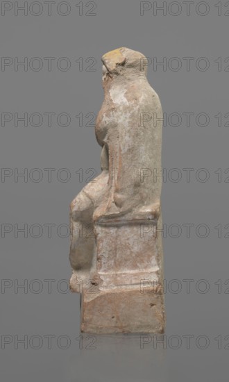 Terracotta figurine of an actor, terracotta, actors, ancient theater, male figurines. Figurine of an actor sitting on a pedestal. The head is turned to the right. The legs are crossed at the ankles. The man is wearing a loincloth and a cloak covering the left side of the body. The left arm is bent at the elbow, and the hand rests on the right cheek. The right hand holds the cloak on the left shoulder. The face is covered by a caricatured mask with a beard. Preservation condition: fragment of the cheek, left hand, and left calf is imprinted. 332–30 BC; Hellenistic period, Greece, sculpture, height 18.2 cm, A weathered stone sculpture of a seated figure shown in profile on a rectangular base, with worn contours and rough texture; the form has rounded shoulders, an arm resting along the side, and a bent knee, with areas of surface erosion and chips. The stone displays a palette of muted colors including pale beige, light gray, dusty pink, and touches of ochre yellow, with patches of white...