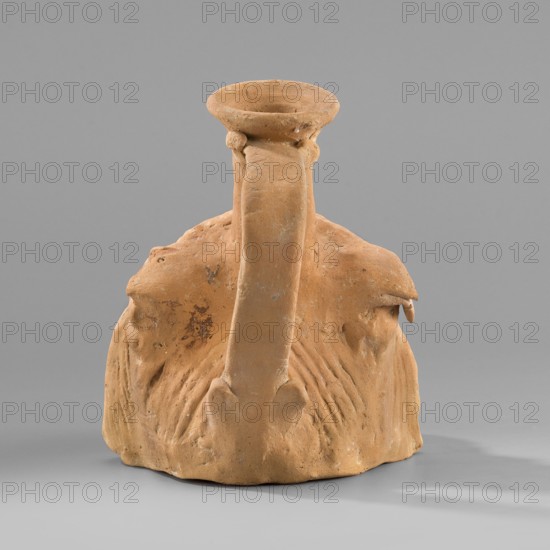 Vessel with a belly in the shape of a comic mask, unknown Greek workshop, plastic vessel, theatrical mask motif, Hellenistic period, 330–30 BC, Greece, vessel; height 10.6 cm, width 9 cm, depth 11.7 cm, weight 0.210 kg., The image shows a terracotta-colored clay vessel with a rounded base and a tall narrow neck that flares into a wide rim, placed against a neutral gray background; the surface of the vessel is textured with a few rough patches and incised lines, and there are areas of darker brown discoloration and lighter beige wear.