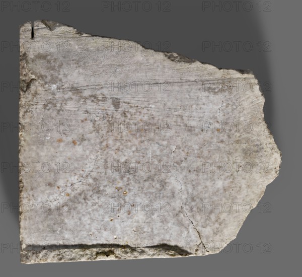 Fragment of an orthostat with relief decoration, unknown Neo-Assyrian workshop. Fragment of a stone wall-cladding slab orthostat with a relief representation of a man shooting a bow. The realistically carved horse head, with a trimmed mane and a low horseshoe-shaped plume on top, features a meticulously rendered bridle. The rider, shown in left profile, holds a drawn bow with an arrow in his left hand and wears a helmet. As is customary, the eye is shown full face. The long beard and mustache are schematic and give the impression of being unfinished. In the upper left corner, traces of an inscription having been chiseled off are visible, and similar traces appear between the bow and the rider's head, indicating the slab's secondary use. Neo-Assyrian art, 7th century BC c. 668–c. 631 BC, reign of Ashurbanipal. From the South-Western Palace Kuyunjik/ancient Nineveh, orthostat; height 28 cm, width 32 cm, depth 7.8 cm, weight 10.6 kg., A roughly rectangular stone slab with an irregular bro...