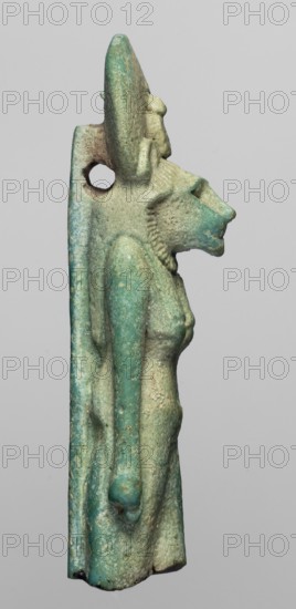 Amulet - figurine of a lion-headed goddess Sachmet?, Figurine of the goddess Sachmet with a lion's head topped with a solar disc with a uraeus, in a tripartite wig and a long narrow robe. The lower legs are missing, but the figure seems to be walking, with its arms lowered. On the back pillars. 664–332 BC; Late Period, Egypt, amulet, height 5.8 cm, width 1.7 cm., A weathered statuette shown in profile depicting a figure with an animal-like head and a human torso, rendered in a hard material with a textured surface. The figure has a prominent elongated snout, a mane-like textured area at the jaw and neck, and a rounded headdress or disk rising behind the head with a small perforation through the upper back area. The torso shows female anatomical contours with slender arms hanging alongside the body and a long vertical back pillar that extends to the base. Surface wear and pitting are visible across the piece, with colors including green, turquoise, pale blue, and areas of beige or light...