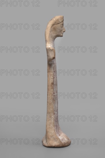 Idol with a full-bodied female head, Standing female figure with a torso flattened on both sides, a plastically developed head slightly tilted forward. Dressed in a long robe, highlighted only by geometric, polychrome patterns. The face is plastically modeled and slim: long, narrow nose; large, straight mouth with lips slightly parted in a smile; sharp chin; slim cheeks with prominent cheekbones; large, convex, almond-shaped eyeballs; broad eyebrow arch; high forehead. Hair arranged symmetrically, parted in the middle, slightly crimped a kind of swallowtail, long hair falling over the shoulders. Slightly defined, wide neck. Hands represented by wide projections extending to the sides, ends slightly curved forward. Dress flared at the bottom, forming a kind of base for the figurine. Traces of white and red polychrome visible throughout; robe shows barely visible geometric patterns—braids and checks. c. 550 BC mid-6th century BC. Boeotia. Sculpture. Height 22.6 cm; width 10 cm; depth 5.1...
