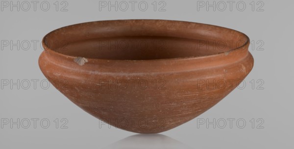 Medum type bowl, Medum type bowl with carination under the rim. Rim diameter smaller than the diameter of the shoulders. Rounded bottom. Straight, slightly flaring rim. Vessel made on the wheel of Nile clay, surface leveled. The bottom and lower part of the vessel finished to about half its height with a knife or similar tool. The surface of the vessel is covered with a layer of engobe . Vessel colour – red. c. 2686–c. 2181 BC; Old Kingdom, Edfu. Ceramic Egyptian pottery vessel, clay vessel; height 9 cm, diameter 21.1 cm rim, diameter 21.5 cm shoulders., A reddish-brown clay bowl with a rounded body and a slightly flared rim sits against a neutral gray background; the bowl shows surface scratches and small chips along the rim, a few lighter speckles and patches of wear on the exterior, and subtle variations in the reddish-brown color ranging to darker and lighter tones.