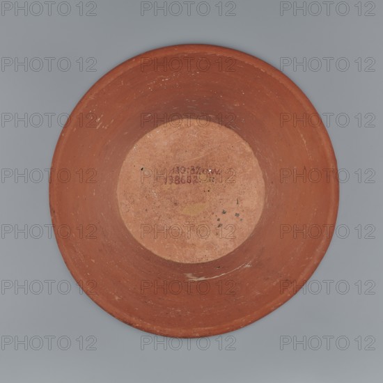 Deep, cup-shaped clay bowl with a slightly convex bottom and sides arching upwards, straight flaring rim. Made of Nile clay NB1, covered with engobe mixed with red ochre and thoroughly polished; vessel color red. Well-preserved with slight clay damage on the rim. Height 15.1 cm, lip diameter 27.6 cm, bottom diameter 11.8 cm, weight 1.3 kg. Stylistically compared to Late 4th–6th Dynasty / Old Kingdom pottery 4th dynasty c. 2494–c. 2181 BC; late 6th dynasty noted., A round shallow bowl-like object viewed from above, primarily reddish-brown with a lighter, more worn circular area in the center; the interior shows a few small dark spots and scuffs, and the rim and sides have several lighter scratches and worn patches; the background is a flat muted gray.