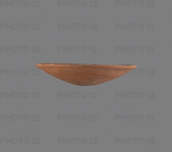 Bowl, Low bowl with a rounded bottom and a widening, rounded rim. Nile clay, fine-grained, well-fired. Smoothed surface. Formed on a slow-rotating wheel. Bowl glued together from several fragments. Dated c. 2686–2181 BC, Old Kingdom late Old Kingdom, provenance Edfu. Vessel, height 4.7 cm, diameter 22.9 cm., A shallow, curved ceramic bowl with a rounded rim is centered against a plain gray background; the bowl shows a terracotta surface with variations of reddish-brown and hints of orange and lighter worn patches, and its texture appears slightly rough with subtle speckling.