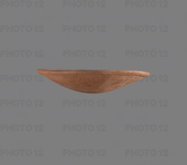 Bowl, Low bowl with a rounded bottom and a widening rounded rim. Nile clay, fine-grained, well-fired. Smoothed surface. Formed on a slow-rotating wheel. Bowl glued together from several fragments. c. 2686–c. 2181 BC; Old Kingdom late Old Kingdom, Edfu. Vessel. Height 4.7 cm, diameter 22.9 cm rim., A shallow, rounded ceramic bowl with a rim is shown floating against a plain background; the bowl is primarily terracotta brown with subtle variations in tone and some darker speckles and lighter patches, and the background is a muted gray.