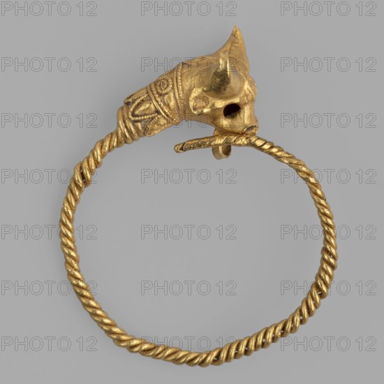 Earring decorated with a bull's head. Earring with a round ring twisted from two wires, pointed at one end, terminating at the other with a solid bull's head made of repoussé sheet metal. The animal's neck is decorated with filigree decoration: volutes and lanceolate leaves. A round loop is attached under the muzzle to hold the other end of the wire. Late 4th century BC, Greece. Jewelry; earring. Height 2 cm, width 1.8 cm, depth 0.5 cm, weight 2 g., A circular twisted metal band in gold color with a decorative end shaped like an animal head, also gold, featuring carved details and openings where the eyes would be, set against a plain light gray background.