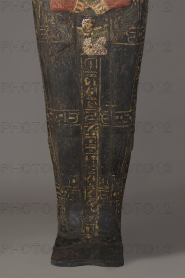 Lid of the sarcophagus of a man named Setau, Setau ca. 1479–1295 BC. Sarcophagus lid, c. 1479–c. 1295 BC; New Kingdom, late 18th Dynasty, from Deir el-Medina tomb 1352, western necropolis. Height 192 cm, width 50 cm, depth 34 cm. A vertical band of inscription runs through the center – the sacrificial formula. Two columns of text along the edge of the lid and three columns across divide the surface into six fields. The legs are clearly defined, the arms are modeled, the hands are clenched. On the chest is a richly polychrome seven-row necklace; below the hand is a depiction of the winged goddess Nut. The head is sculpturally detailed: face painted red with large almond-shaped eyes set slightly obliquely; eyeballs clearly defined; pupils and eyebrows highlighted in black. The nose is straight and strongly flattened; the mouth small with wide, full lips. The wig is schematically decorated with yellow stripes; the face and hairstyle painted black and rendered in the round. Setau once had ...
