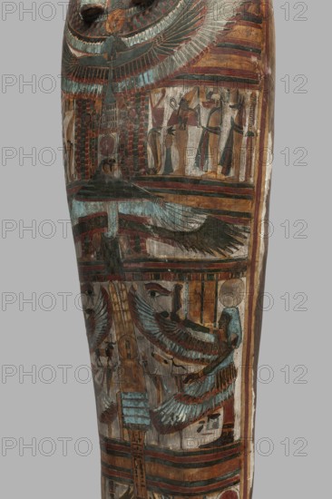 Mummy of Panepi in a cartonnage, doorkeeper of the temple of Amun Panepi, Panepi ca. 945–715 BC. Richly decorated cartonnage. The deceased's wig and mask are sculpturally detailed. On the chest is a necklace with a plant and geometric ornament. Below is a centrally located i3-w fetish mounted on a djed sign, behind which an inscription begins. On the sides of the fetish are winged goddesses Isis and Nephthys and the Horuses of Edfu. At the base of the fetish are depictions of Upuaut. Above the fetish is a ram-headed bird with outstretched wings Amun-Ra and Wadjet cobra, Osiris, and the three Sons of Horus. The deceased's hands are not modeled. c. 825–715 BC; Third Intermediate Period, late 22nd–23rd Dynasty, Western Thebes. Sarcophagus, mummy, cartonnage. Height 170 cm; width 40 cm; depth 29 cm; weight 37.5 kg., A tall wooden object with painted decorative panels showing stylized winged figures and standing humanlike figures, rendered in muted tones of blue, green, brown, red, black, a...