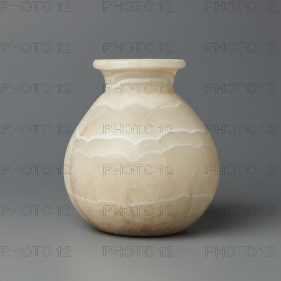 Vessel, globular vessel with a short, wide neck and a large upturned spout, flattened bottom; stone; ca. 1550–1069 BC, New Kingdom, Egypt; vessel; height 14.8 cm, width 13.4 cm, weight 1.32 kg., A rounded vase with a narrow neck and flared rim sits against a plain background; the vase is mainly creamy off-white with subtle bands and scalloped patterns in slightly darker beige and light tan tones, and there are faint natural striations and small speckles on its surface, while the background and surface it rests on are shades of gray.