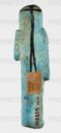 Shabti overseer Amenemone. A shabti figurine depicted in living attire, wearing a knee-length loincloth. In her left hand, bent at the elbow and folded across her chest, she holds a hoe placed on her right shoulder; the hoe's blade reaches down to her hand. The right arm hangs along the body. The face is small, triangular, with only the eyes clearly defined; other facial details are blurred. On the head is a three-part, smooth wig tied with a headband, the ends of which fall down the back; the ears are uncovered. A column of hieroglyphic text on the front of the headband. Text, hoe and headband, and facial details painted in black paint. c. 1069–c. 945 BC, Third Intermediate Period, 21st Dynasty, Egypt. Shabti; height 8 cm, width 2.3 cm., A small, elongated object with a rounded top and an irregular side protrusion in a turquoise-blue color with mottled lighter and darker areas; a vertical black line runs down the center from the top and branches into a short horizontal black stroke ne...