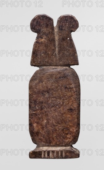 Amulet — cartouche with two ostrich feathers; amulet in the shape of a cartouche topped with a crown of ostrich feathers., Late Period, Egypt, 664–332 BC. Materials/technique: amulet. Height 4.3 cm; width 1.4 cm. Inscriptions/marks: cartouches, crowns, feathers., A single vertically oriented carved object with a weathered surface in shades of brown and dark brown, showing a rounded rectangular midsection and a narrower top section with two rounded protrusions, all resting on a short rectangular base with vertical grooves; the background is a pale light gray.