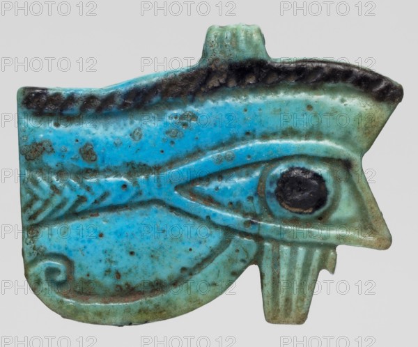 Amulet - Udjat Eye, Udjat eyes, ancient Egyptian amulet Eye with openwork eyeball, grave good, amulet representing a body part; ca. 945–656 BC, Third Intermediate Period, 22nd–25th Dynasty, Egypt; height 3.4 cm, width 4.2 cm., A turquoise-blue carved amulet shaped like an eye with textured grooves and raised ridges, showing areas of darker teal and black patina along the upper edge and around a circular central pupil; the surface has mottled spots of darker blue and brownish-green discoloration, and the piece has a small protrusion at the top and a notched, ridged extension at the bottom.