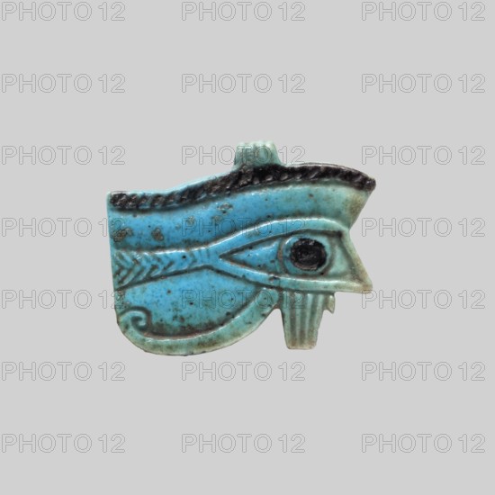 Amulet — Udzhat Eye;, Udzhat eye amulet, grave good; Eye with openwork eyeball, details marked schematically; ca. 945–656 BC, Third Intermediate Period, 22nd–25th Dynasty, Egypt; amulet; height 3.4 cm, width 4.2 cm., A small carved object shaped like an eye with a stylized eyebrow and surrounding decorative lines, rendered in bright turquoise with areas of darker teal and black along the raised edges and in the central circular pupil; the surface shows speckled brownish spots and slight discoloration, with a smooth, glazed texture and subtle wear along the contours, set against a plain light gray background.