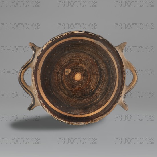 Skyphos mug with depictions of ducks, Late Geometric period, ca. 725–700 BC. Skyphos with a profiled belly. Just below the rim are two painted bands with a delicate line. The metopes depict ducks with long necks and legs, in front of which are stylized flowers; one bird image is very poorly preserved. Behind each bird's head is a swastika motif. Silhouette technique? Vices placed at the maximum width of the belly. Inner surface covered with matte, faded paint. A reserved line is left a short distance from the bottom; the bottom is undecorated. Technology: visible traces of turning. Varnish worn away in places. Clay light yellow with many inclusions. Surface shows significant abrasions and chips. Condition: spout damaged. Visible conservation additions old glue. Clay color: black 7.5 YT 2.5/1; red 10 R 4/4. Provenance/attribution notes: attributed to Attica; dated to Late Geometric 9th–8th century BC. Dimensions: height 9.0 cm; width 19.6 cm; depth 15 cm; weight 0.352 kg., A round shall...