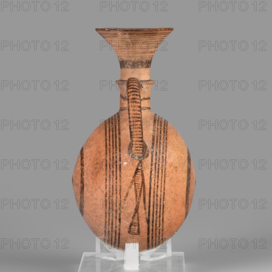 Bottle, geometric motifs, Cypriot pottery, vessels, circles iconography. Amphora with a round, slightly flattened flask-like belly. Brown-black decoration of concentric circles of varying thickness on the belly, horizontal lines on the rim, and a fine zigzag. 1050–750 BC Cypriot-Geometric Period, Cyprus. Vessel, amphoriskos. Height 10.4 cm, width 6.7 cm., A rounded ceramic vessel with a narrow neck and flaring rim sits upright on a clear support against a neutral gray background; the vessel is primarily terracotta orange with dark brown to black painted linear and geometric banding, including several vertical stripes down the body and a patterned vertical handle that connects the rim to the shoulder, and the rim shows concentric horizontal lines and darker worn areas.