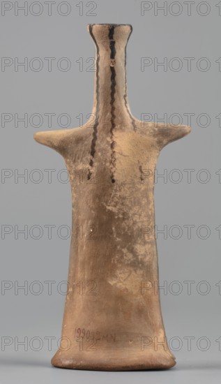 Idol, female idol made of orange clay, votive figurine, 6th century BC 1st half of the 6th century BC, Boeotia; figurine; height 14.4 cm, width 6.7 cm, depth 2.9 cm, weight 0.10 kg., A tapered, humanlike clay figurine in earth tones of brown and tan stands upright against a plain gray background, with a narrow neck and flared top, short horizontal arm-like projections, and wavy dark brown painted lines running down the front of the neck and torso, along with irregular darker and lighter patches across the surface that suggest weathered texture.