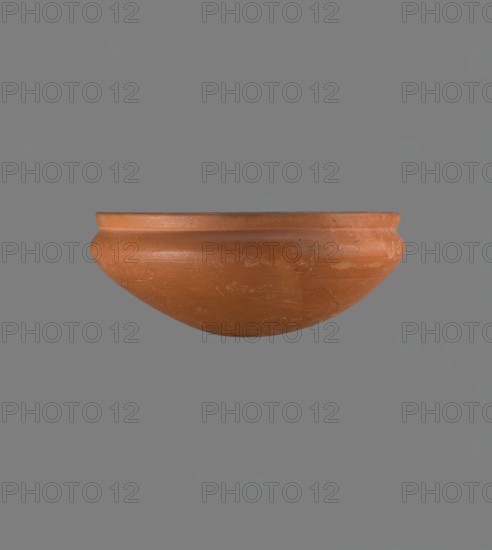 Medum-type bowl, Medum-type bowl with characteristic carination under the rim. Rounded bottom. Straight, slightly flaring rim. Narrow, sloping shoulders. The diameter of the rim is smaller than the diameter of the vessel's shoulders. Nile clay, light red, well fired. Surface leveled, covered with a layer of engobe and polished. On the outside of the bottom part is a hieroglyphic sign in the shape of a bird, probably the letter m. Vessel color red. Complete, very well preserved. Comparative references: Junker, Giza I, pl. XII no. 16; Reisner, A History of Giza Necropolis, vol. I, fig. 282. Ca. 2686–2181 BC Old Kingdom, Edfu; vessel height 8.9 cm, rim diameter 20.9 cm, shoulder diameter 21.5 cm., A terracotta bowl with a rounded profile and a slightly flared rim is shown centered against a plain gray background; the bowl is reddish-brown with variations in tone and some lighter patches and scuff marks on its surface.