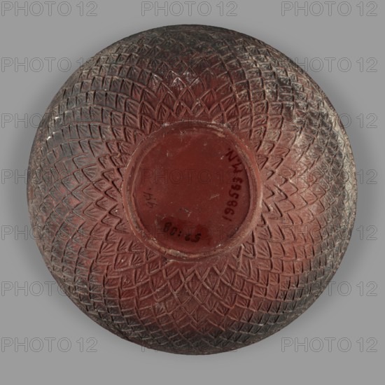 Megarian bowl, unknown Ionian workshop, classified Gallic scenography, end of 2nd–beginning of 1st century BC, Ionia Turkey/Greece, vessel, height 8.5 cm, width 13.1 cm, weight 0.178 kg, A round object with a carved geometric pattern covering its surface, showing a central recessed circular area surrounded by a textured design of repeated diamond and triangular shapes; the object displays shades of reddish-brown with darker brown and grayish areas, and the background is a smooth medium gray.