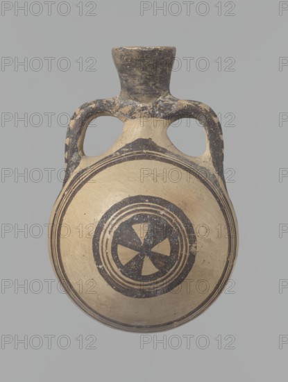 Canteen, Cyprus. Cypriot ceramics, White Painted I . Canteen decorated with concentric circles. Vessel with a spherical, slightly flattened body width on one side 8.5 cm, on the other 7.3 cm and two vertical, cylindrical handles and a narrow neck. Slightly flaring spout reconstructed. Pinkish clay. Creamy engobe, black-brown decoration. On the handles, horizontal lines framed on the sides by thick lines, which are connected at the neck at the attachment point, while below the handles they intersect beneath the attachments. The two flattened sides of the body are decorated identically. Two sets of concentric circles, composed of four lines each: two narrow lines framed on both sides by wider lines. The outer line of the outer band overlaps the neck of the vessel and slightly extends over the handle mounts, widening in these places. The center of the inner band is filled with a Maltese cross motif. Good condition: reconstructed spout and upper half of the neck. Limescale deposits have be...