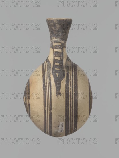 Canteen, Cyprus. Canteen decorated with concentric circles. Vessel with a spherical, slightly flattened body width on one side 8.5 cm, on the other 7.3 cm and two vertical, cylindrical handles and a narrow neck. Slightly flaring spout reconstructed. Pinkish clay. Creamy engobe, black-brown decoration. On the handles, horizontal lines framed on the sides by thick lines, which are connected at the neck at the attachment point, while below the handles they intersect below the handles. The two flattened sides of the body are decorated identically. Two sets of concentric circles, composed of four lines each: two narrow lines framed on both sides by wider lines. The outer line of the outer band overlaps the neck of the vessel and slightly extends over the handle mounts, widening in these places. The center of the inner band is filled with a Maltese cross motif. Good condition: reconstructed spout and upper half of the neck. Limescale deposits have been removed from the surface of the vessel....