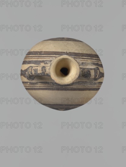 Canteen, Cyprus. Cypriot ceramics, canteen, White Painted I . Canteen decorated with concentric circles. Vessel with a spherical, slightly flattened body width on one side 8.5 cm, on the other 7.3 cm and two vertical, cylindrical handles and a narrow neck. Slightly flaring spout reconstructed. Pinkish clay. Creamy engobe, black-brown decoration. On the handles, horizontal lines framed on the sides by thick lines, which are connected at the neck at the attachment point, while below the handles they intersect below the handles. The two flattened sides of the body are decorated identically. Two sets of concentric circles, composed of four lines each: two narrow lines framed on both sides by wider lines. The outer line of the outer band overlaps the neck of the vessel and slightly extends over the handle mounts, widening in these places. The center of the inner band is filled with a Maltese cross motif. Good condition: reconstructed spout and upper half of the neck. Limescale deposits have...