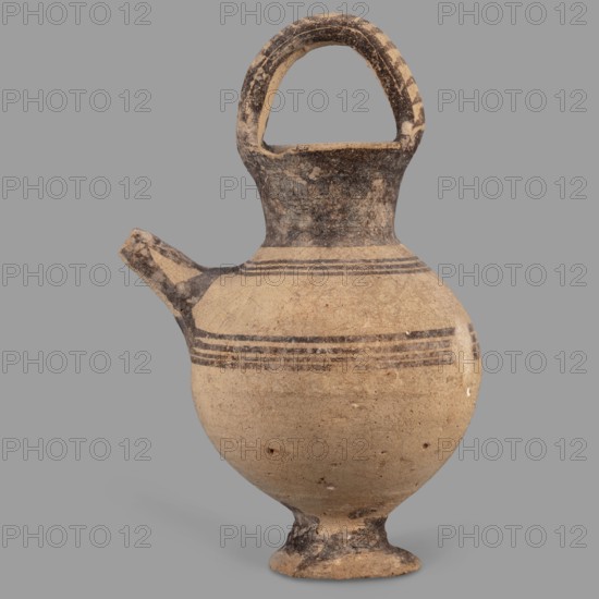 Jug on a ring-shaped foot, from which a low, wide stem extends, transitioning into a belly. The upper part of the spherical body has a narrow spout. The wide, flaring neck terminates in a simple spout, from both sides of which a vice, shaped like a flattened cylinder, extends above the vessel. Decoration in brown varnish: concentric circles surrounding the vessel four below and three above the spout. The foot and stem are varnished on the top, and the neck and side edges of the vice are varnished on the outside. The upper part of the vice is decorated with a row of transverse stripes. A strip of varnish encircles the spout at the base, and three stripes decorate the spout on the sides and top. Terracotta vessel, Cyprus, Geometric period I Cyprus-Geometric District IA, 1050–950 BC. Height 12.8 cm; width 6.5 cm., A rounded ceramic vessel with a narrow neck, a looped handle arching from the neck to the rim, and a short spout projecting from the shoulder. The vessel has a small footed base...