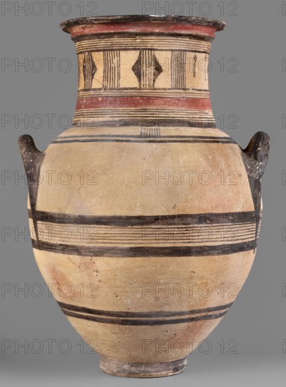Amphora, Cyprus, geometric motifs, Cypriot pottery. Large amphora with two horizontal handles, rounded shoulders, and a neck narrowing in the middle, ending with a profiled rim. Decoration in red and black: on the neck formed by sets of lines, stripes, vertical lines, and triangles; on the belly formed by black lines and stripes. Dated 850–750 BC. Type: vessel. Height 64.2 cm, width 42.4 cm., A large rounded ceramic vessel with a narrow base, a wide body, a neck that flares at the rim, and two short handles on opposite sides, showing an overall beige-tan surface with areas of light reddish tones and worn spots; decorative horizontal bands in black encircle the body and neck, with a wider red band near the top, and a patterned section on the neck featuring vertical black stripes and diamond-shaped black motifs; the rim and handles are darker, appearing blackened or charcoal-colored, and the surface shows age-related blemishes and uneven coloration against a neutral gray background.
