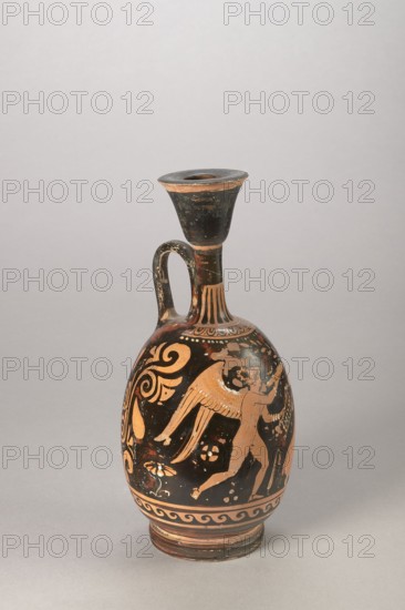 Red-figure aryballus lekythos with a depiction of Eros and a woman, Darius Painter active 340–320 BC, 340–320 BC, Apulia; vessel lekythos, aryballus lekythos, height 23.3 cm, width 10.7 cm, An upright ceramic vessel with a narrow neck, flared rim, and single curved handle stands on a flat surface; the body is primarily black with orange and reddish-brown painted figures and decorative motifs, including a winged human figure in orange on one side, swirling floral and leaf patterns around it, a band of repeating wave-like ornament near the base, and vertical fluted decoration at the shoulder; the rim and base show worn orange and darkened areas, and small chips and surface wear are visible on the black and orange painted surfaces.