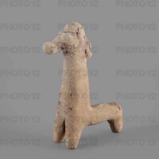 Horse figurine, unknown Cypriot workshop. Schematic horse figurine. Plastically modeled muzzle, strongly rounded at the tip. Eyes marked with convexities. Mane attached. Neck strongly elongated in relation to the rest of the body, flattened at the rear edge, imitating a mane. Body narrow in relation to the neck, cylindrical. Front legs spread out to the sides, also cylindrical. Hind legs designed as a single unit in the form of a cylinder. Traces of polychrome visible on the surface: muzzle and mane reddish-brown, eyes highlighted in black. Traces of black paint also visible on the neck and chest of the animal. 750–600 BC Cypro-Archaic period II. Cyprus. Figurine. Height 10.8 cm, width 7.8 cm., A rough-textured, light beige clay figure stands against a plain gray background, with a tall, elongated central body and an arched horizontal limb forming a right-angled shape; the top area has several rounded protrusions suggesting a head with bulbous features, and the surface shows patches of...